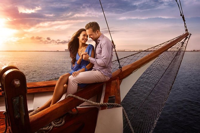 Two people at a candlelit table on the deck of a boat after dark